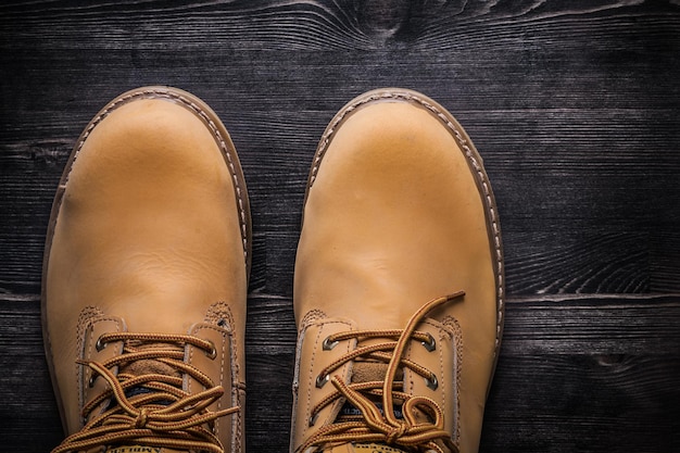 Pair of safety working boots on wood board construction concept