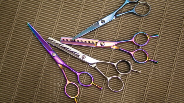 A pair of scissors are laying on a mat with the word hairdresser on the bottom.