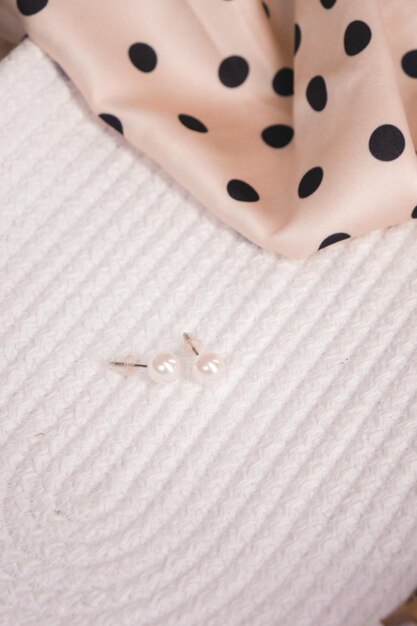 A pair of small earrings with the letter s on them