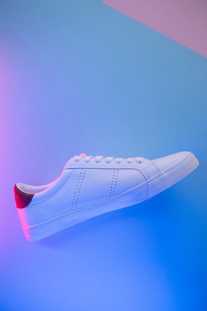 Photo pair of sneakers on color background, top view.