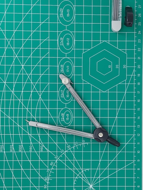 Пара пружинных компасов на зеленом коврике для резки с дифференциальным фокусом