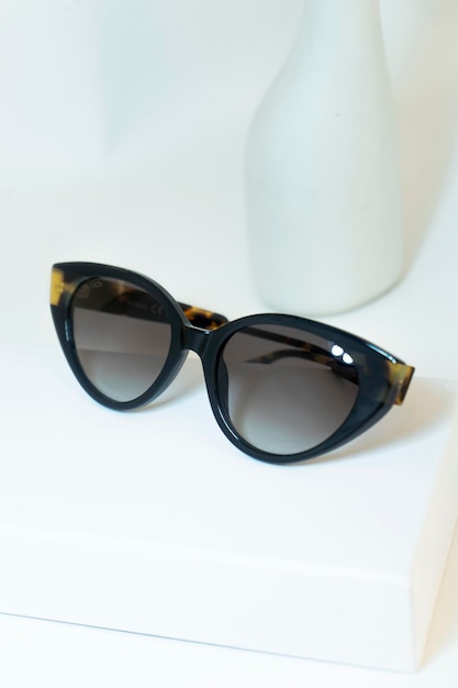 A pair of sunglasses with a black frame and gold trim.