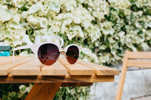 Pair of sunglasses over a wooden table, summer and vacation concept  