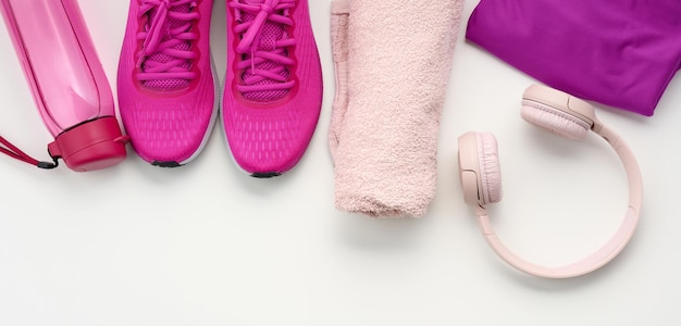 Photo a pair of textile purple sports sneakers wireless headphones a towel and a bottle of r