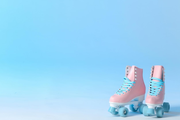 Pair of vintage roller skates on color background Space for text