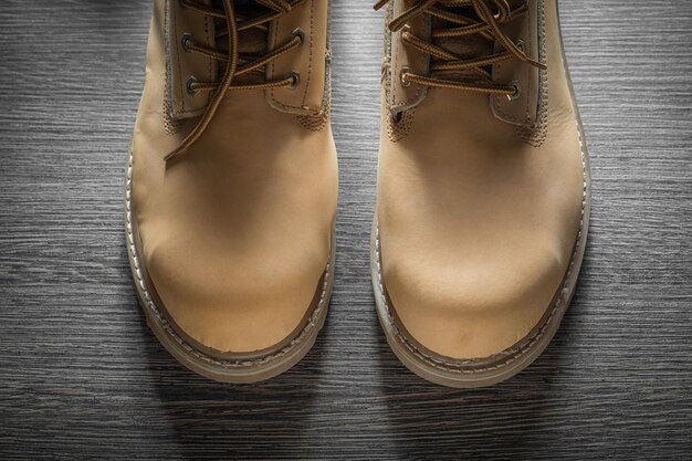 Pair of waterproof working boots on wooden board