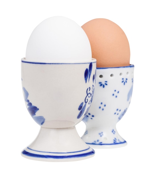 Pair of white and brown boiled eggs in cups