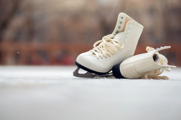 一対のホワイトフィギュアスケートは、オープンアイススケートリンクにあります。