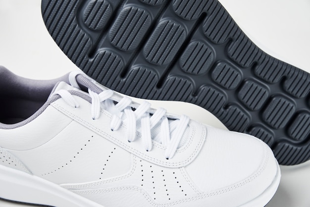 Pair of white male sneakers on white. Fashion stylish sport shoes, close up