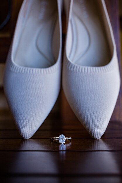 Photo a pair of white shoes with a diamond ring on the left