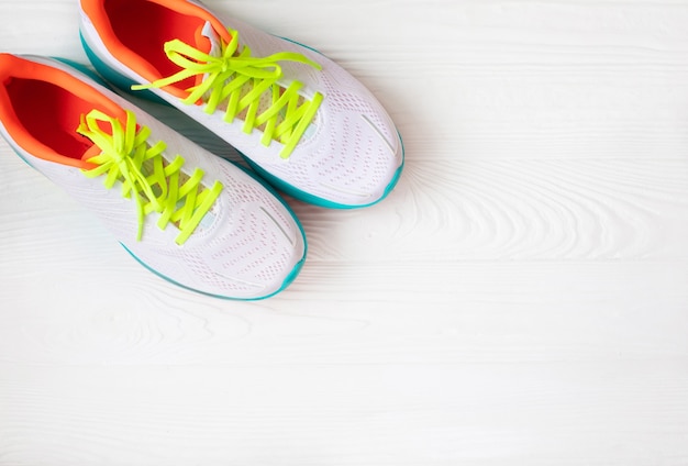 Pair of white sneakers on wooden background