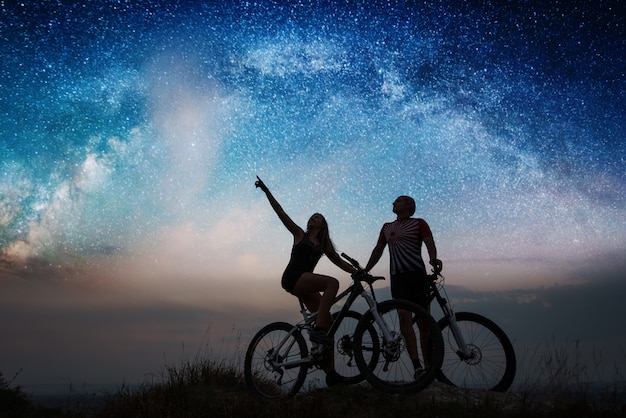 pair with mountain bikes under night starry sky