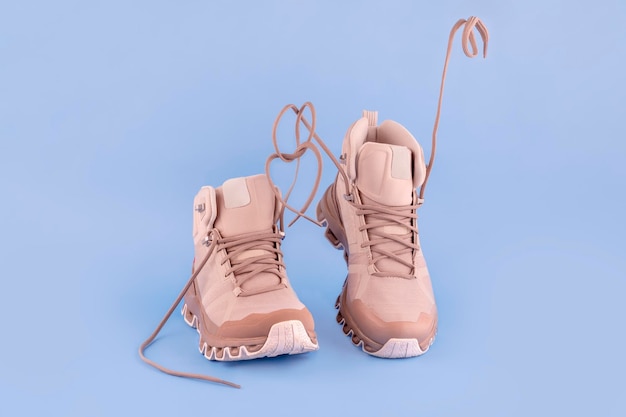 Pair of woman cream hiking bootsisolate on a blue background