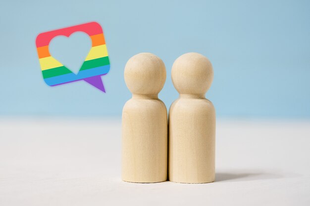 Photo pair of wooden figures in love stand close together.