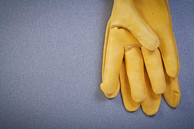 Pair of working safety gloves on grey background construction concept