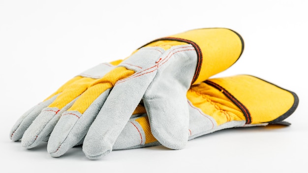 Pair of yellow construction gloves on a white insulated background