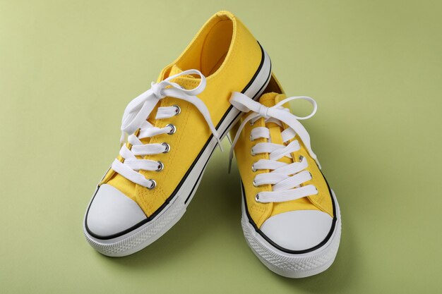 Pair of yellow sneakers on green background