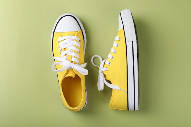 Pair of yellow sneakers on green background