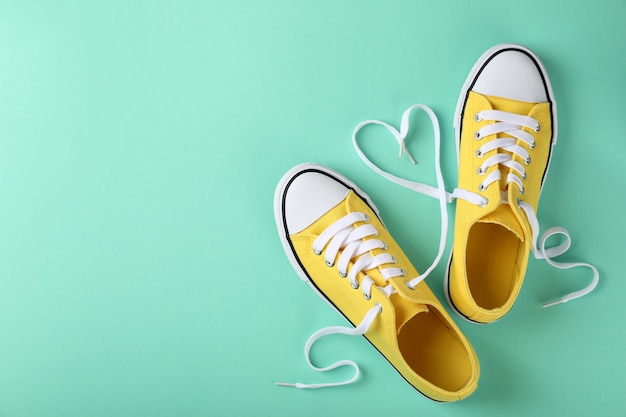 Pair of yellow sneakers on mint background