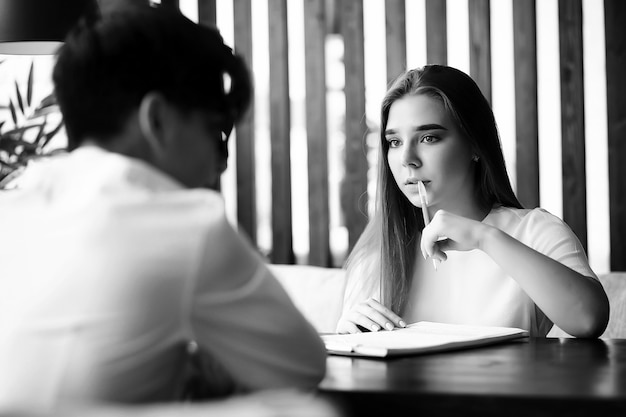 A pair of young people talking at the office table