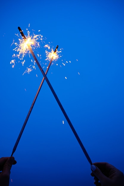 Foto paia di mano che tiene e sparkler bruciante attraversato