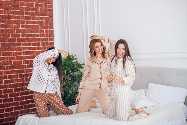 In pajamas. Three young girls having a pajama party and feeling cheerful