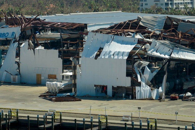 Foto pakhuis met motorboten en jachten vernietigd door orkaanwinden in het kustgebied van florida natuurramp en de gevolgen ervan