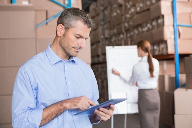 Pakhuismanager die aan tabletpc werken