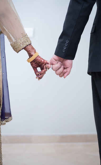 pakistani Indian brides groom holding hands