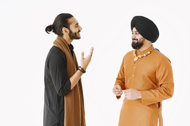 Pakistani man and Indian men in traditional clothes. The friends are talking at white background, isolated. Agremment between countries.