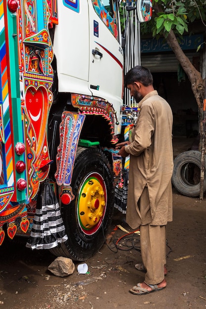 Pakistani truck decoration artists. Colorful Jingle trucks maintenance. Pakistan