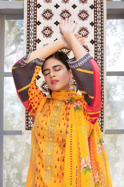 伝統的なデジ ドレスと化粧を身に着けているパキスタンの若い女の子の赤面の肖像画