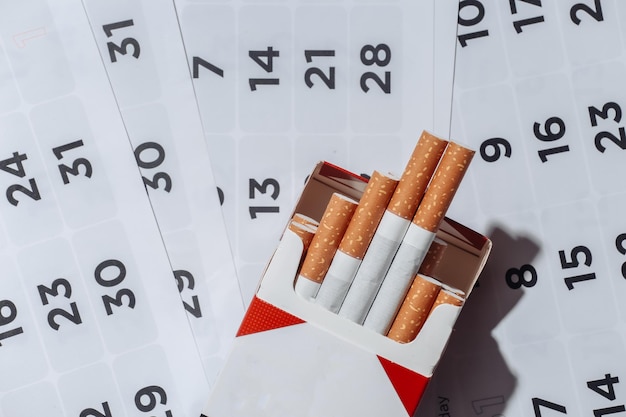 Pakje sigaretten en maandkalender. Stoppen met roken concept
