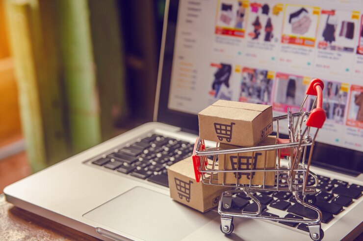 Pakket- of papierdozen met een winkelwagenlogo in een trolley op een laptop toetsenbord