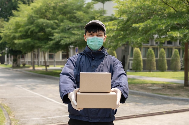 Pakketbezorgingsconcept de jonge afzender die twee dozen met pakketten optilt