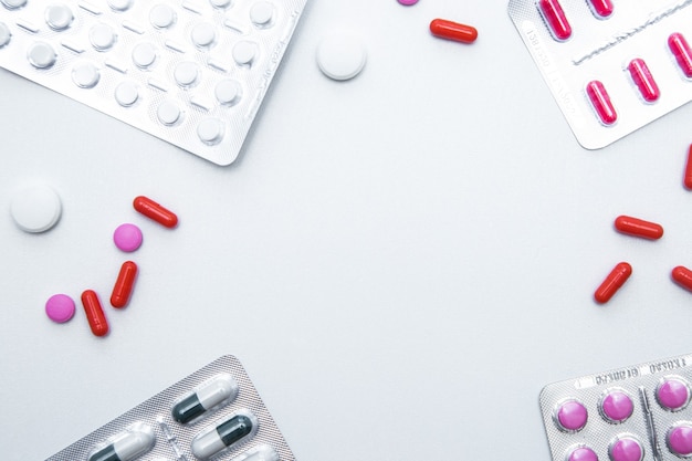 Pakketten en tabletten staan aan de zijkanten van foto's met een handvol tabletten en capsules aan de zijkanten van...