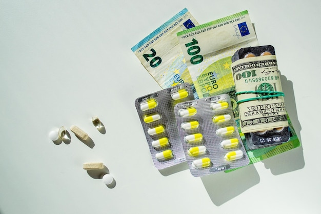 Pakketten van pillen en capsules met verschillende bankbiljetten. Tabletten en hun kosten