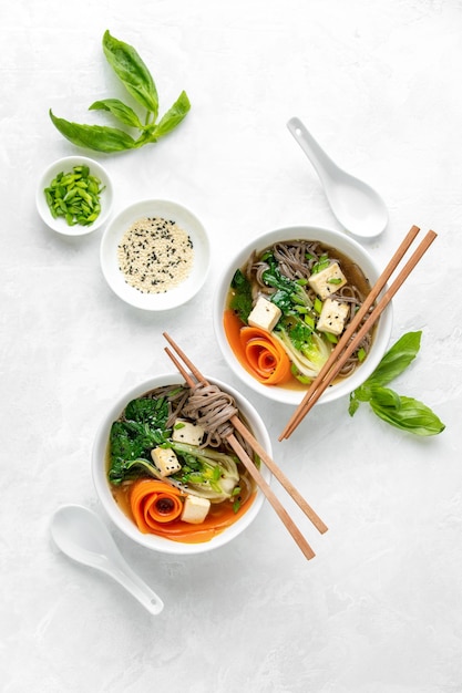 Paksoi en tofu vegetarische udon noedelsoep gekruid met bieslook en sesamzaadjes, van bovenaf gezien