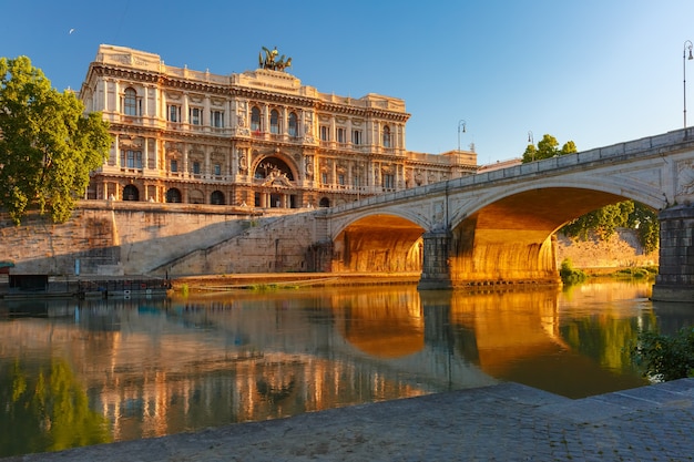 Photo the palace of justice and bridge ponte umberto i with mirror reflection seen from the tiber riverside at sunrise in rome, italy