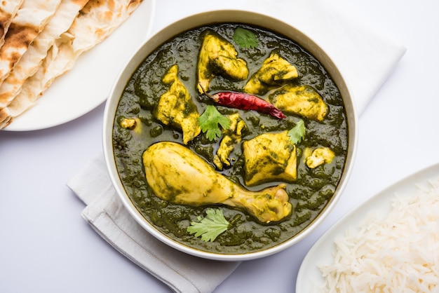 Palak of spinazie Kip of Murg Saagwala geserveerd in een kom met Naan en rijst