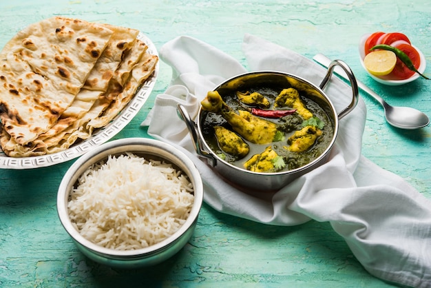 Palak of spinazie Kip of Murg Saagwala geserveerd in een kom met Naan en rijst