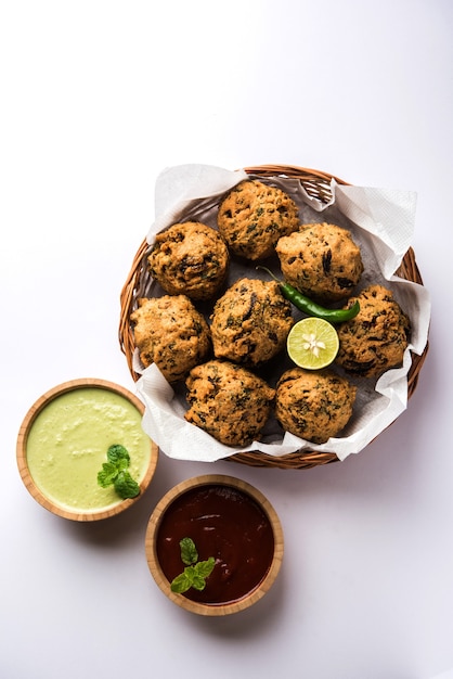 Palak OR Methi Pakora is een Indiase snack geserveerd met groene muntchutney en rode saus, selectieve focus