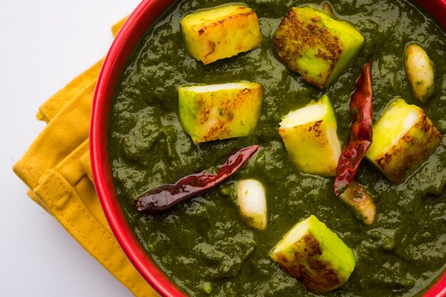 Palak paneer curry bestaande uit spinazie en kwark, populair indiaas gezond lunch- of dinermenu, geserveerd in een karahi met roti of chapati op een humeurige achtergrond. selectieve focus