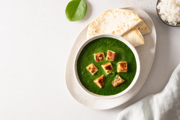 Palak paneer geserveerd basmatirijst op wit