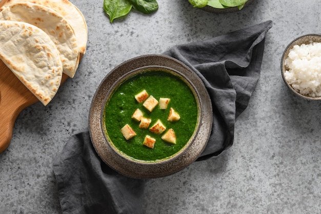 Palak paneer geserveerd met basmatirijst op grijze Indiase vegetarische gerechten van spinazie en paneer