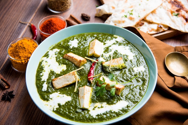 Palak Paneer Masala is a popular North Indian recipe for lunch dinner made using cottage cheese in green spinach curry. usually served with Rice and chapati naan. selective focus