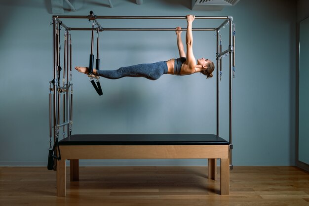 Palates trainer girl posing for a reformer in the gym. Fitness concept, special fitness equipment, healthy lifestyle, plastic