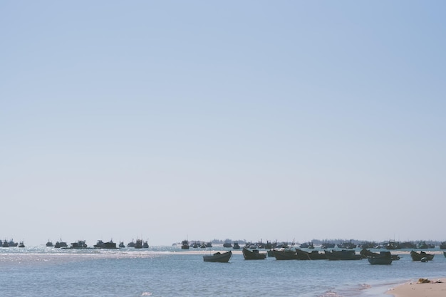 Pale pink purple gray tone seascape clear sky view Real nature beauty background motor boats sail docked shallow water edge sand beach bay calm ripple sea Fishing life style trip leisure travel