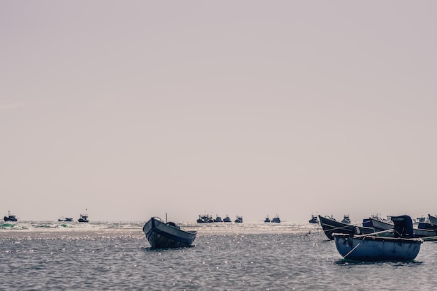 Pale pink purple gray tone seascape clear sky view real nature\
beauty background motor boats sail docked shallow water edge sand\
beach bay calm ripple sea fishing life style trip leisure\
travel