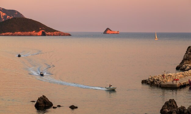 Paleokastritsa corfu grecia luce del tramonto riflessa nel mare barche a vela galleggianti estate